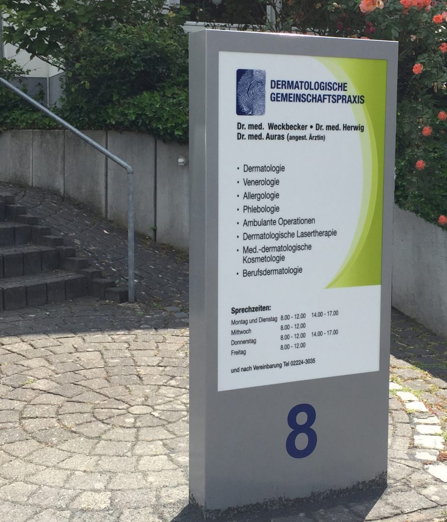 Schild einer dermatologischen Gemeinschaftspraxis mit den Namen der Ärzte, angebotenen Leistungen wie Dermatologie, Venerologie, Allergologie, Phlebologie, Lasertherapie und den Sprechzeiten sowie der Hausnummer 8.